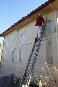 Colorado house during stucco coating process with professional painters