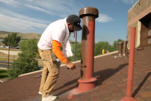Stellar Painting & Remodeling crew member painting exterior rooftop vents on a Colorado home to protect against weather and improve curb appeal.